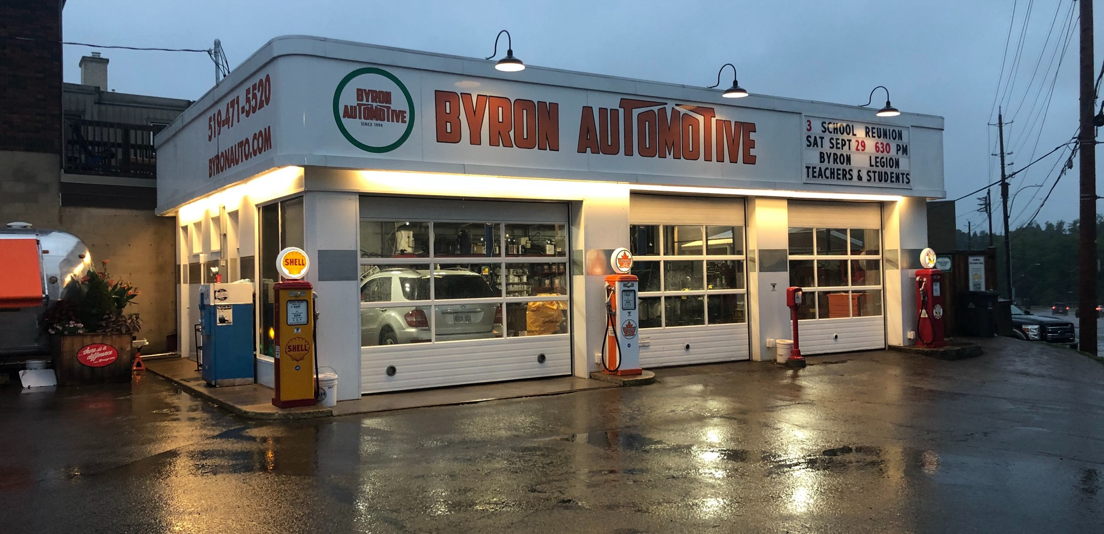 Byron Automotive storefront at dusk, neon sign and vintage gas pumps, Commissioners Road West, London Ontario