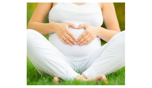 Pregnant woman with hands forming a heart on her belly