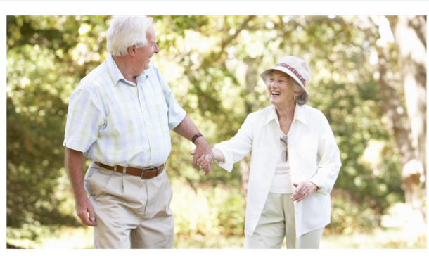 Senior couple walking together outdoors, smiling