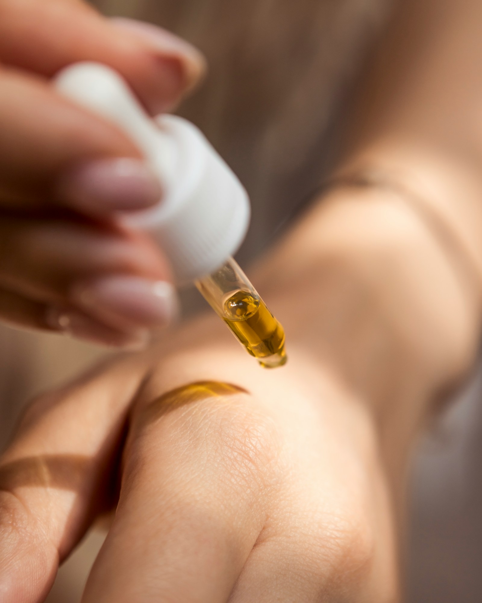 A dropper of golden herbal oil, one form of a custom holistic formula