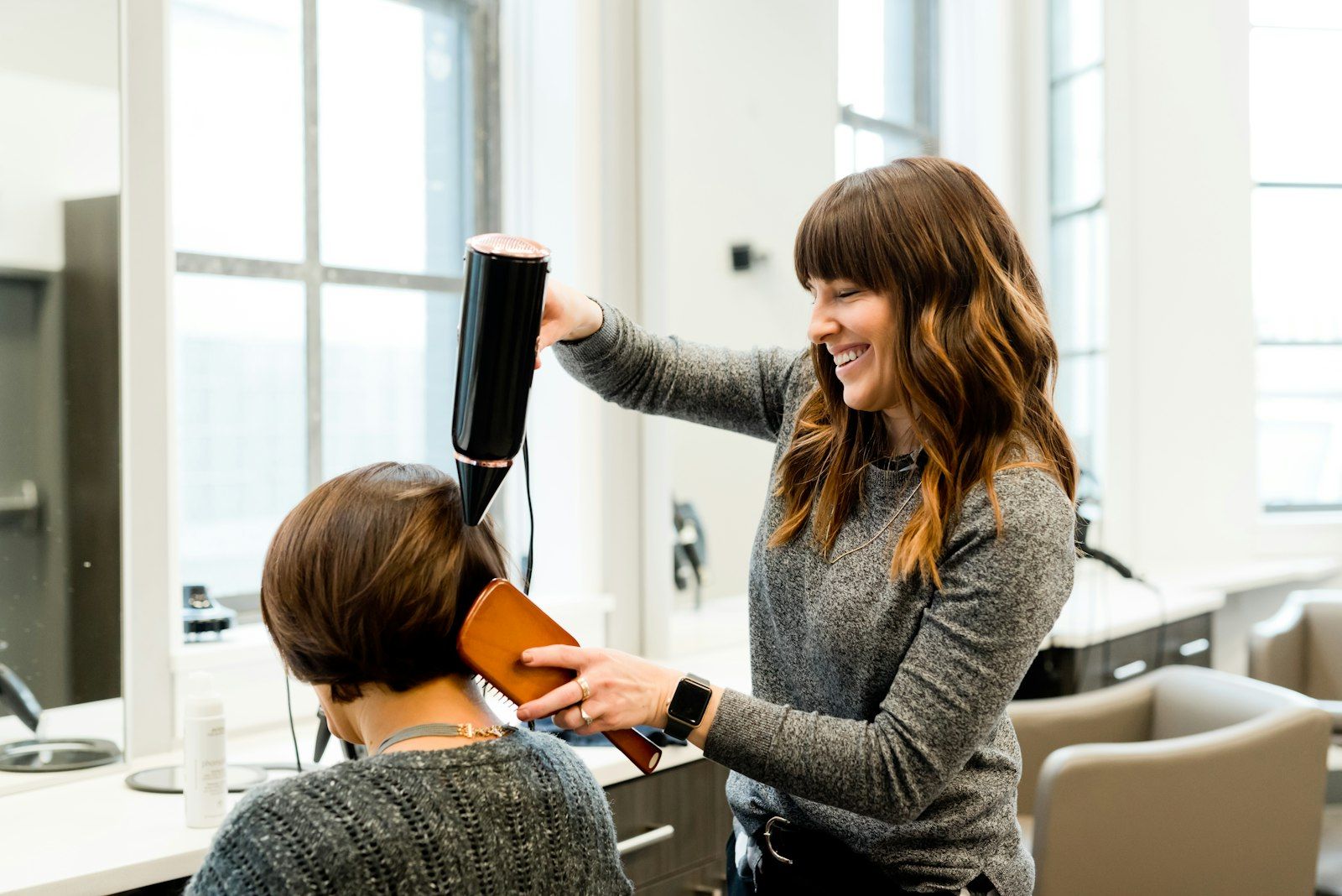 A stylist blow-drying a client's hair at Michael Romeo Hair