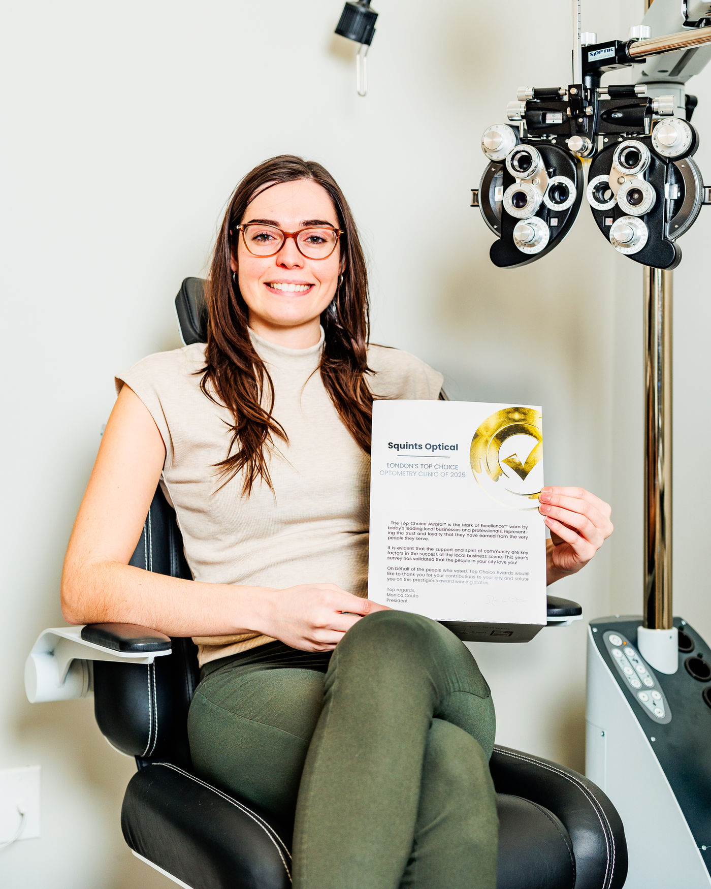 A patient at Squints Optical holding the London Top Choice Optometry Clinic 2025 award