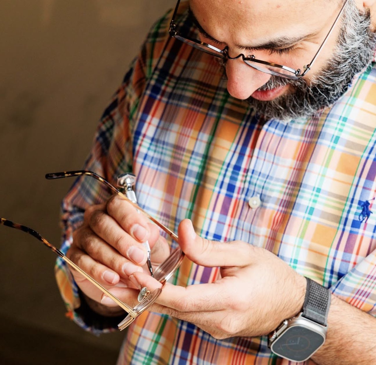 The owner and optician of Squints Optical adjusting a pair of frames by hand, London Ontario