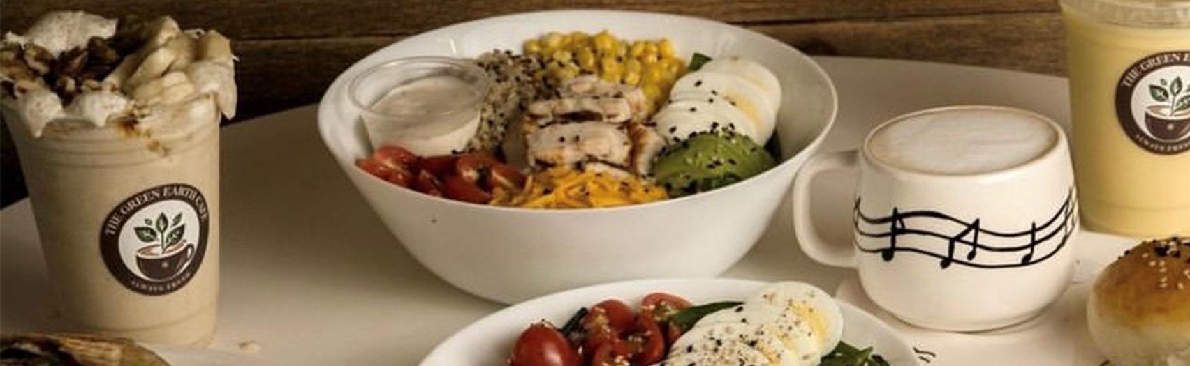 The Green Earth Cafe branded cups, a fresh grain bowl and a latte, London ON